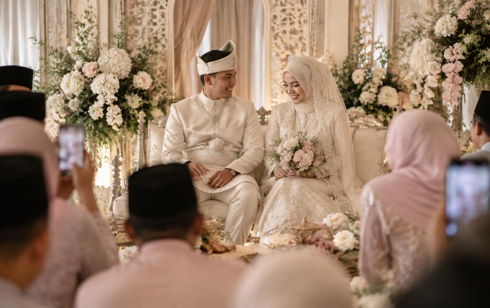 A couple at their wedding reception while guests photograph the moment